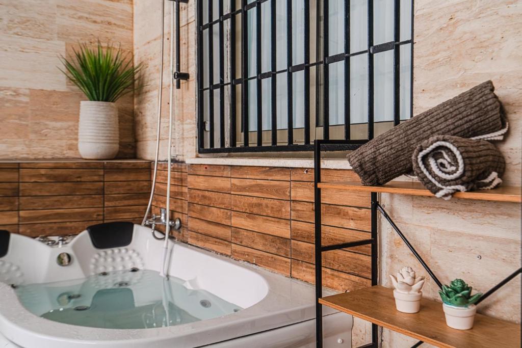 a bath tub in a bathroom with a window at חופשה בממלכה in Ashkelon