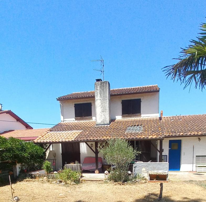 a white house with a chimney on top of it at Maison tarnos in Tarnos