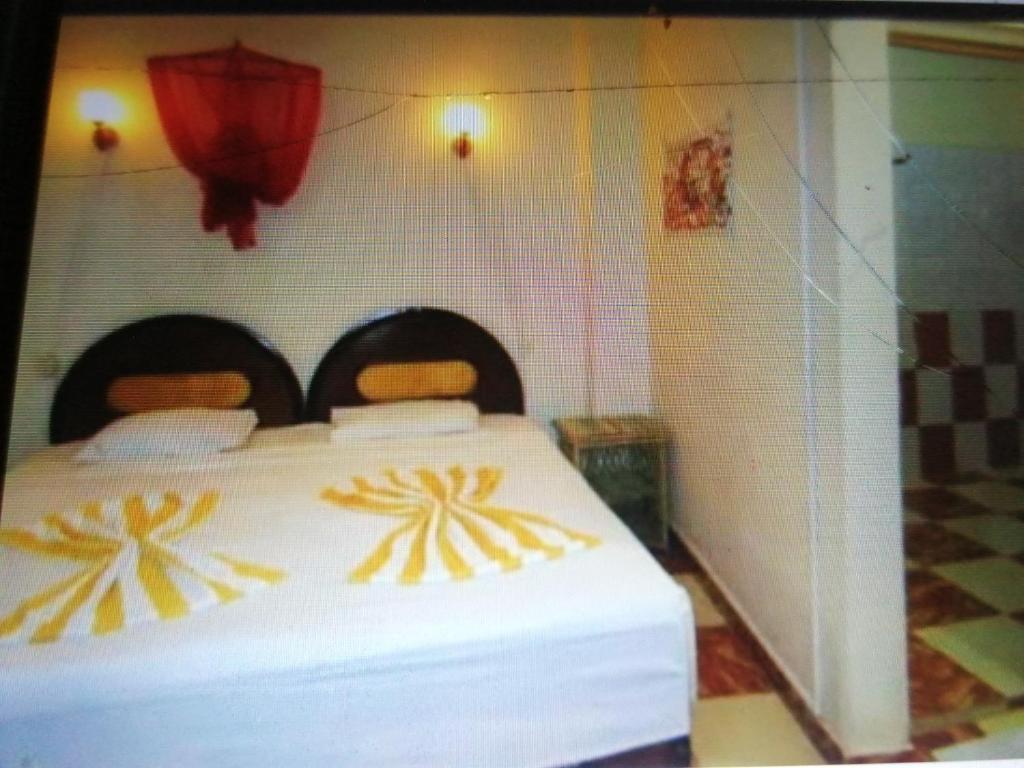 a bedroom with a large bed with yellow and white sheets at Bob marley luxor in Luxor