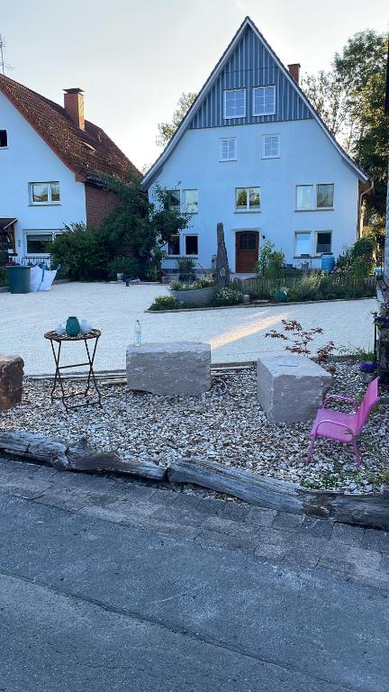 a table and a chair in front of a house at Zimmer Mühlenbach, ein Zimmer in FeWo mit 2 Zi in Schieder-Schwalenberg