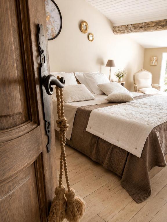 a bedroom with a bed and a wooden door at La maison perchee in Aigues-Mortes