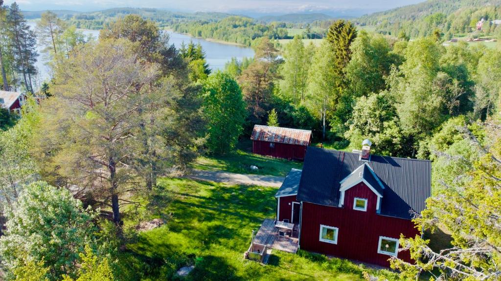 an aerial view of a red barn on a hill next to a lake at Sabines Sjöstuga in Bjärtrå