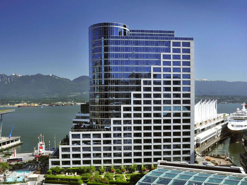 a tall building next to a body of water at Fairmont Waterfront in Vancouver