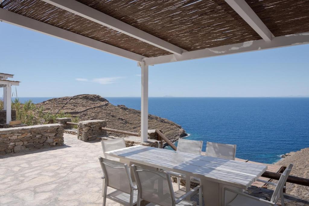 a table and chairs on a patio overlooking the ocean at Off the beaten path! Maisonette & Pool in Kithnos