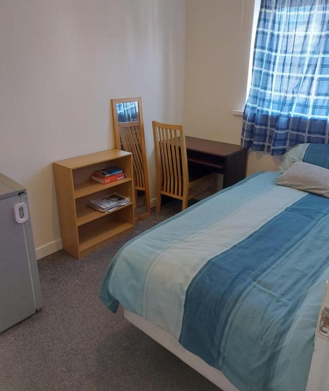 a bedroom with a bed and a desk and a table at Private Room wigan in Atherton
