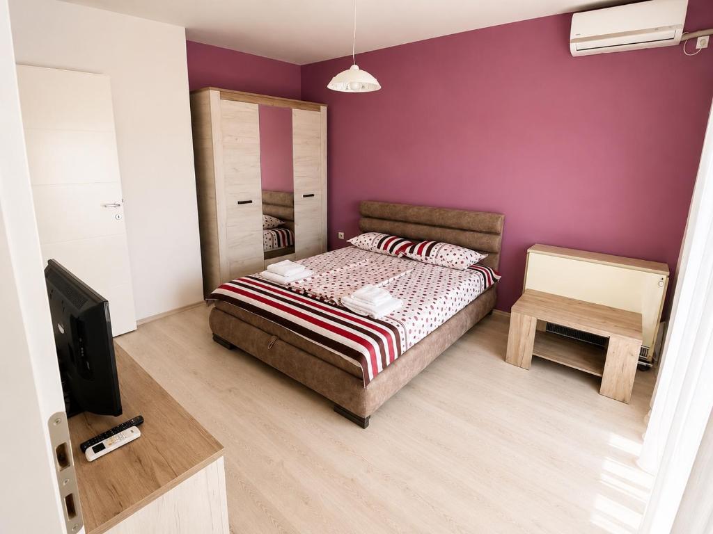 a small bedroom with a bed and a tv at Harmony Relax in Paraćin