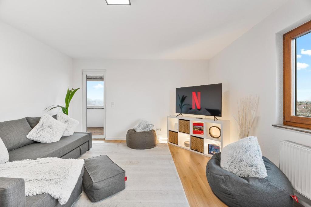 a living room with a couch and a tv at Business & Relax Suite - Panorama - 2 Schlafzimmer - Parkplatz in Sindelfingen