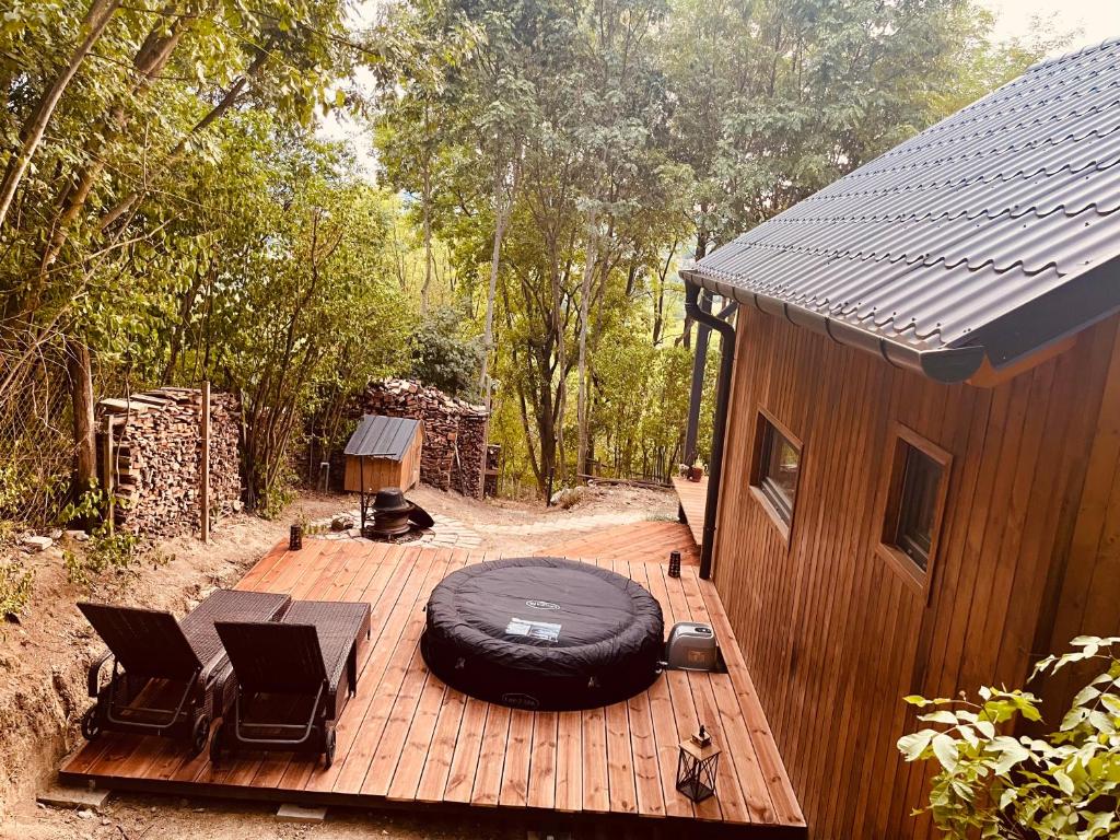 a wooden deck with chairs and a building at Berkenye 2621 in Kismaros