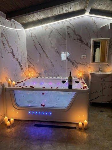 a large bathroom with a tub with a bottle of wine at Good Time 99 in Shezor