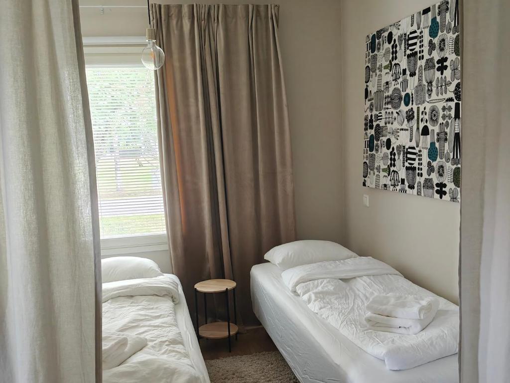 a bedroom with two twin beds and a window at Metsäniitty in Kempele