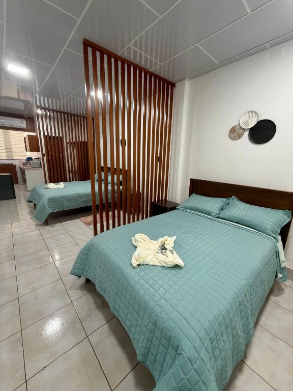 a bedroom with a bed with a green comforter at Finch Nest Malecón in San Cristóbal