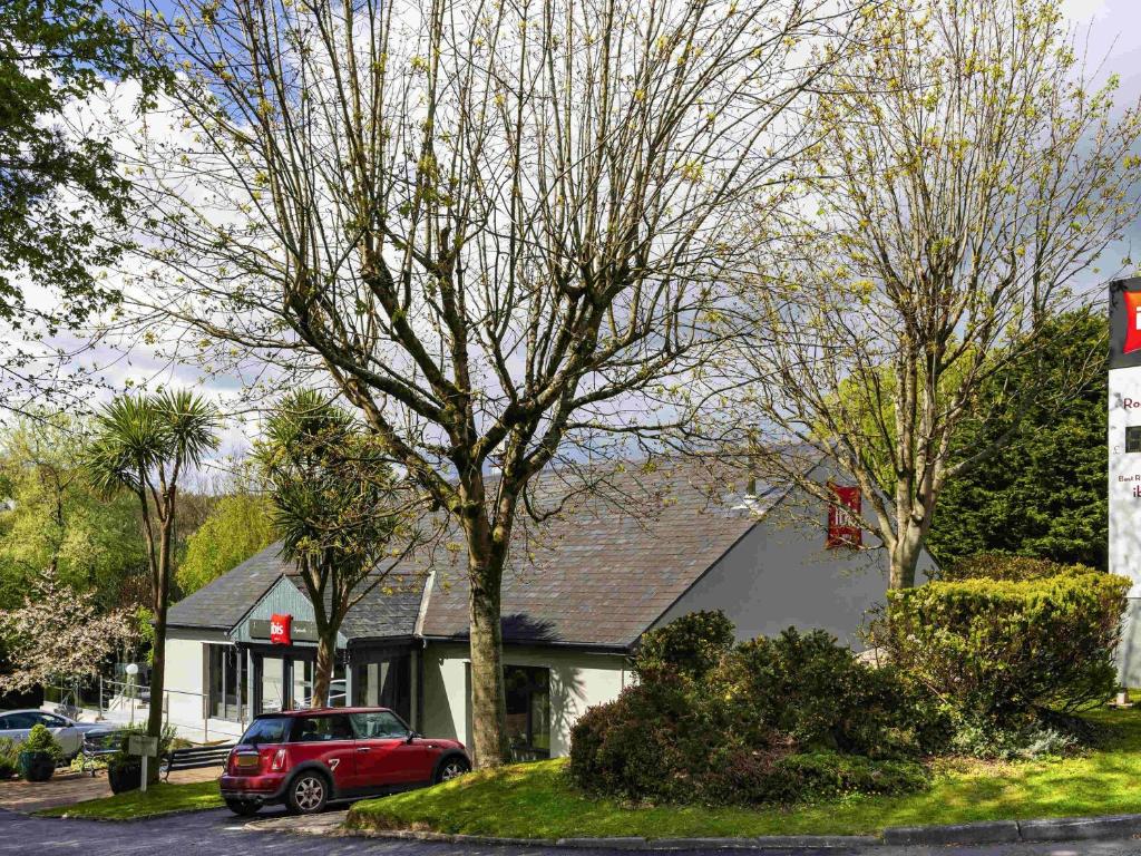 a red car parked in front of a house at ibis Plymouth in Plymouth