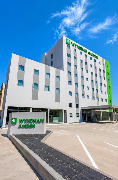 a large white building with a company sign on it at Wyndham Garden Durango in Durango