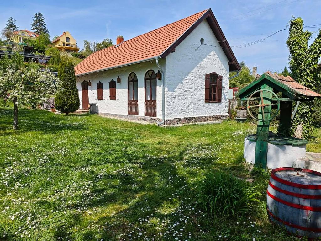 a small white house with a red roof at Badacsonyi Présház in Badacsonytomaj