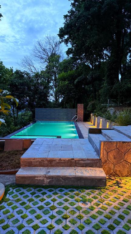 a swimming pool with stairs and a green pool at GAIRAH RESORT in Mundakāyam