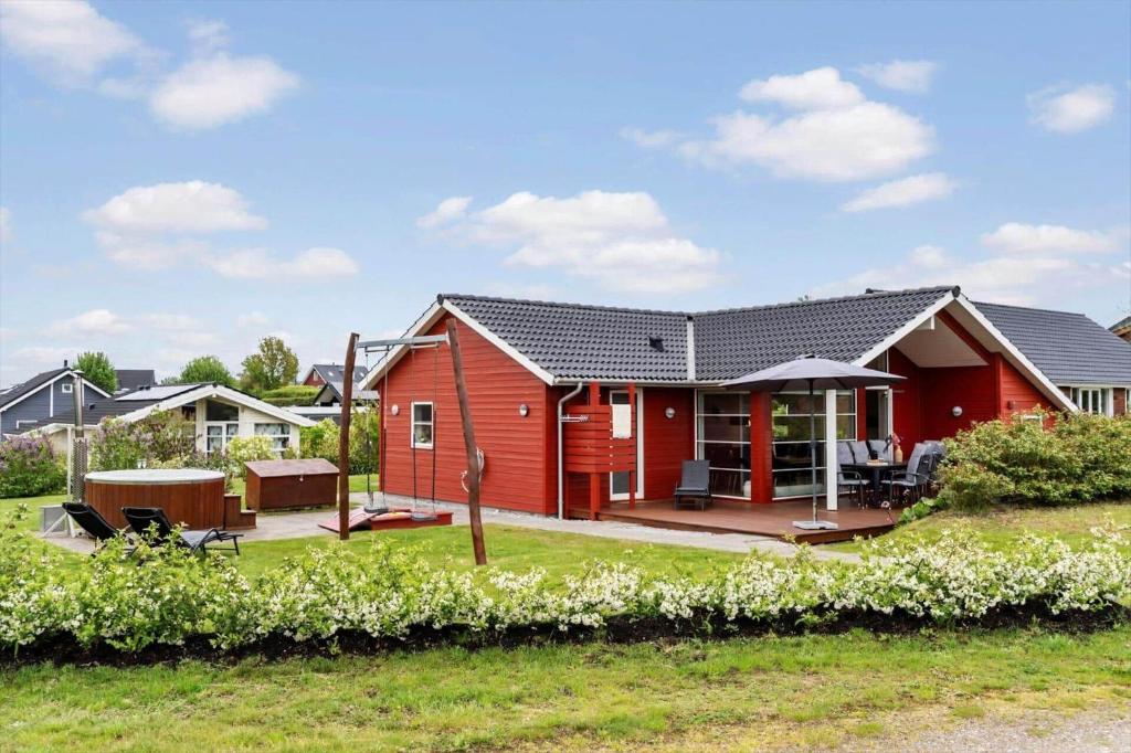 a red house with a patio and a yard at FY416-Frorup-Engparken-10 in Frørup