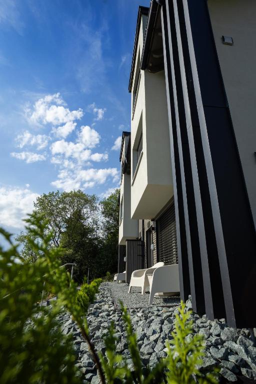 a building with two chairs on a stone walkway at SAUERLAND CHALETS - "Die Chalets Lieblingsplatz" in Winterberg