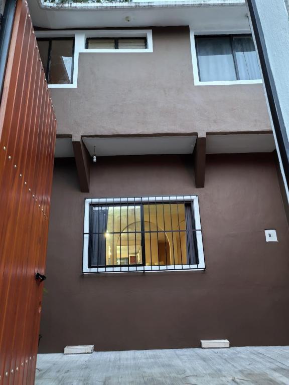 a building with a window on the side of it at Casa Cariño in San Cristóbal de Las Casas