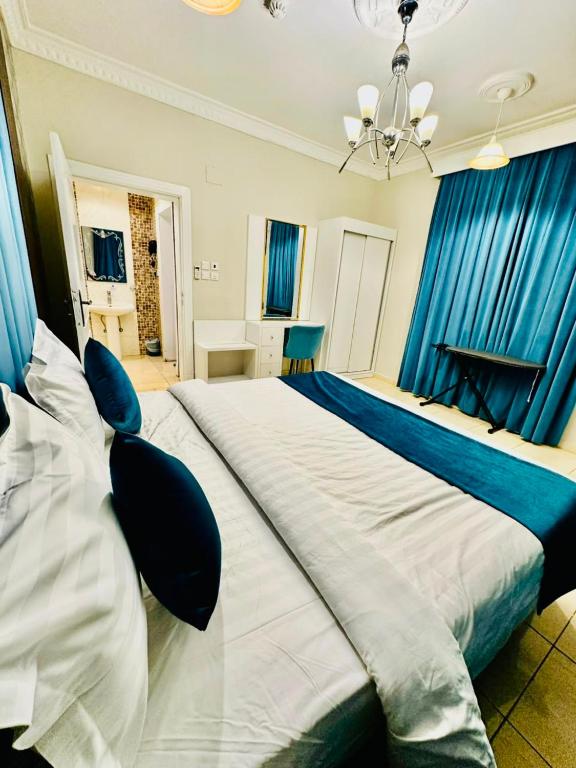 a bedroom with a large bed with blue curtains at شقق ارين المصيف للشقق المخدومة in Al Hada