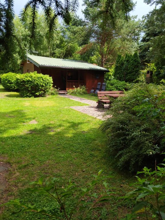 a building with a picnic table and a bench in a yard at Sosnowy Domek in Wólka