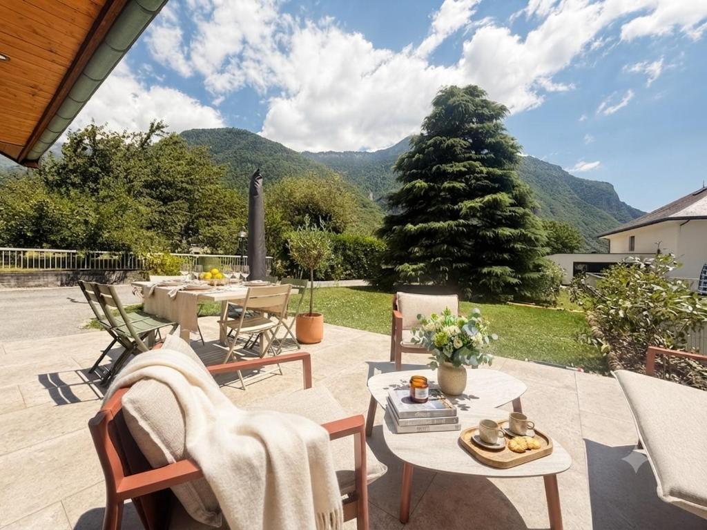 a patio with tables and chairs with mountains in the background at L'Entre Nous Climatisation Terrasse in Saint Avre la Chambre