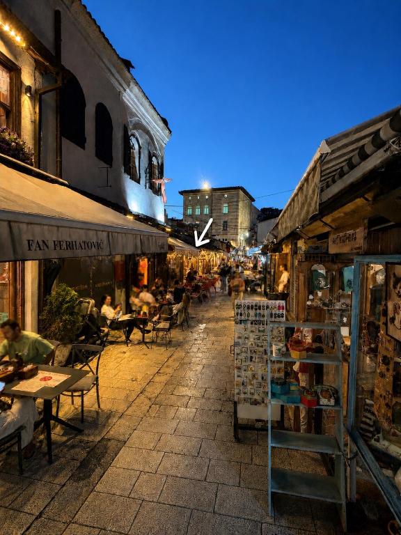a street with tables and chairs and people sitting at tables at EPICENTAR Luxury Jacuzzi & Sauna Apartment in Baščaršija - Private Spa Experience in Sarajevo