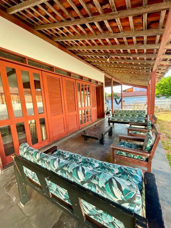 a covered porch with benches and tables on a building at Pousada Casa Atlântica in Luis Correia