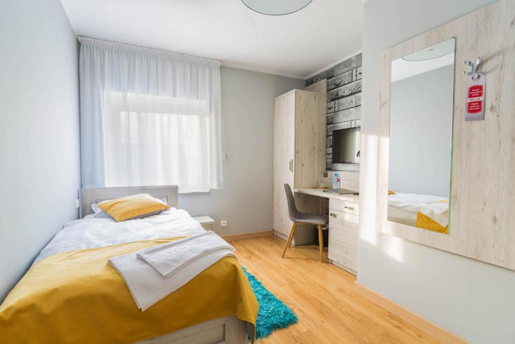 sypialnia z łóżkiem, biurkiem i lustrem w obiekcie MOTEL MO&JA w mieście Leszno