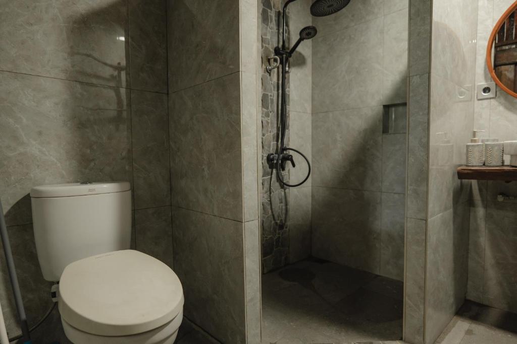 a bathroom with a toilet and a shower at The Wood Cabin in Ambarita