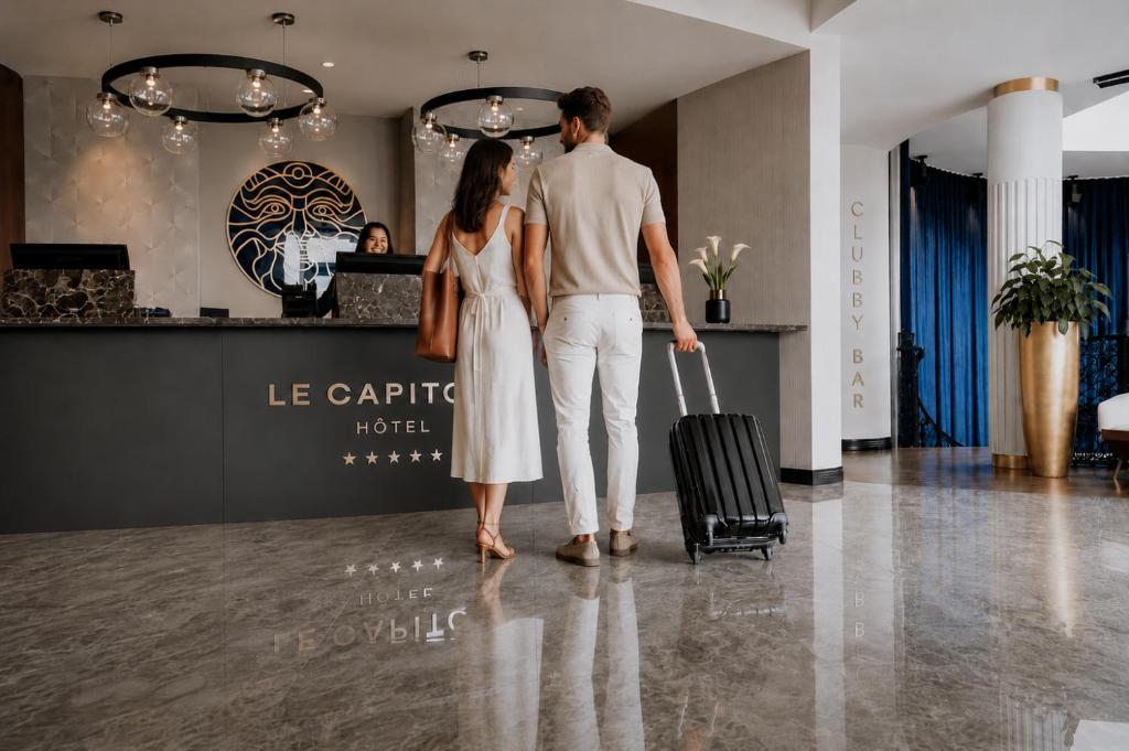 a man and a woman walking with a suitcase at Le Capitole Hotel in Quebec City