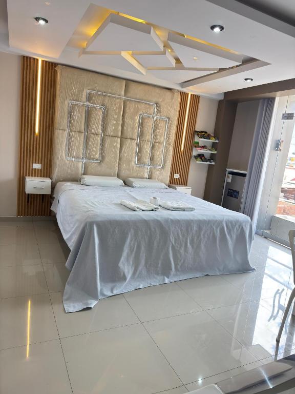 a bedroom with a large white bed with towels on it at Inti killa in Huánuco