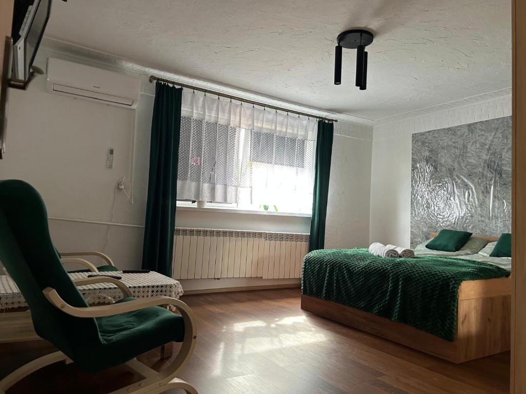 a bedroom with a bed and a chair and a window at U Leona in Przeciszów