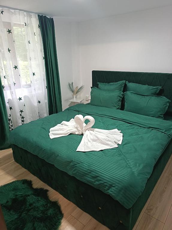 a bed with two white towels on it at Cabana Tonea in Avrig