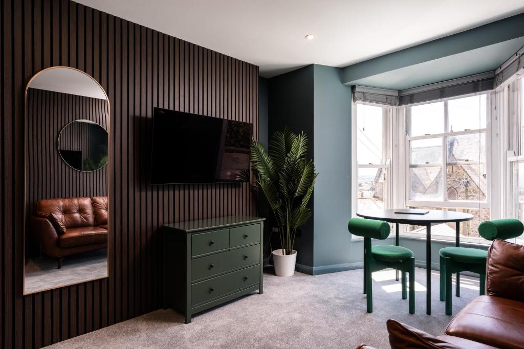 a living room with a tv and a table and a mirror at Modern Studio Apartment with harbour views in Penzance