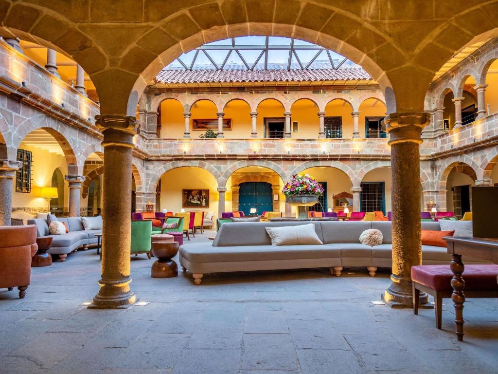 a large room with couches and tables in a building at Novotel Cusco in Cusco