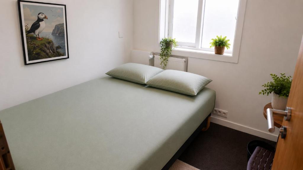 a bed in a room with two pillows on it at 105 Guesthouse Hotel in Reykjavík