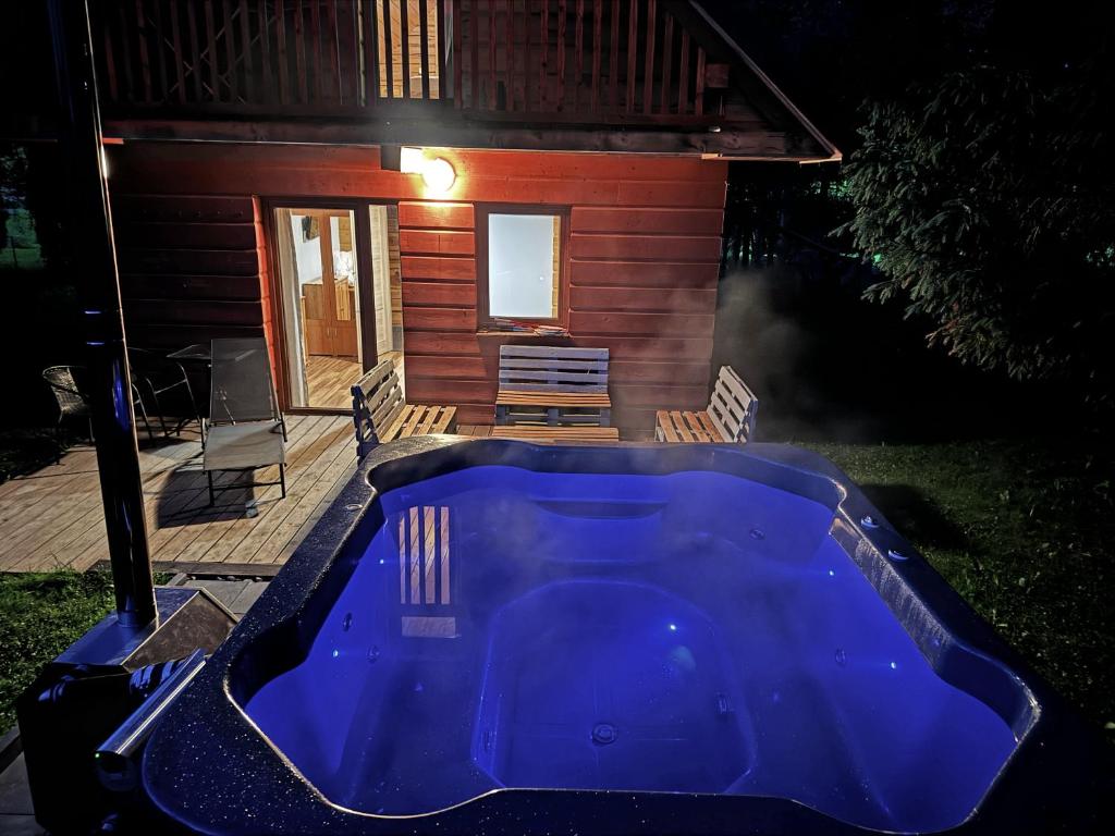 a large blue tub in front of a house at Chata Wilka Bieszczady - Całoroczny dom z bali z 3 sypialniami i balią in Brzegi Dolne