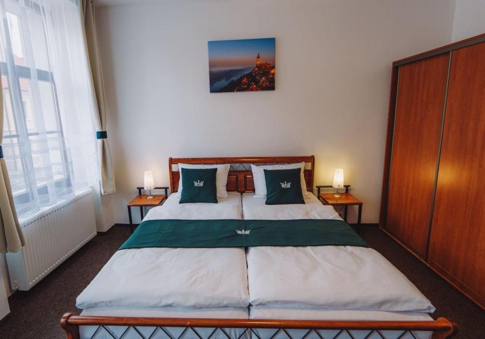 a bedroom with a large bed with two night stands at U Císaře Rudolfa in Mělník