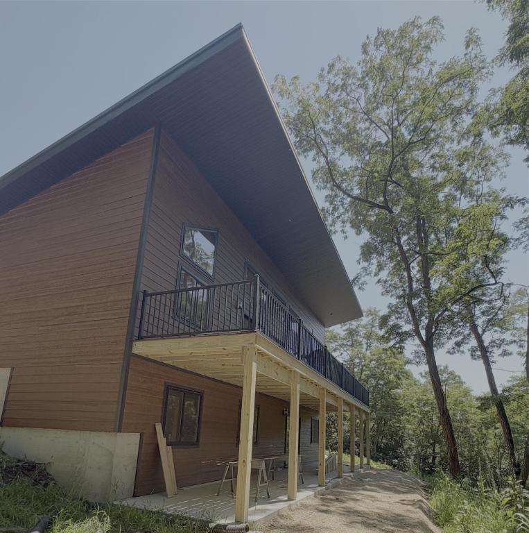a house with a balcony on the side of it at Driftless Destinations in McGregor