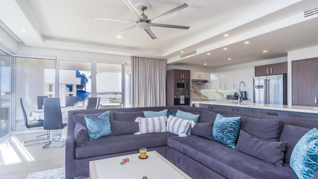 a living room with a couch and a kitchen at Encantame Velero Ground Floor, BeachFront in Playa Encanto