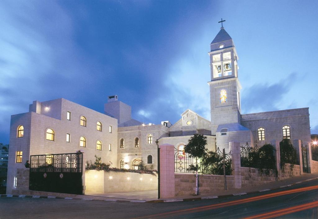 a large building with a clock tower at night at Abrahams Herberge - Beit Ibrahem in Bethlehem