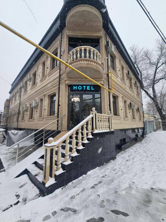 a hotel building with a staircase in the snow at Turg'unTown in Toshkent-Passajir Bekati