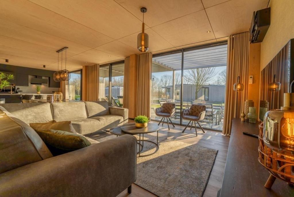 a living room with a couch and a table at Forest Villa 8 persons #724 in Maasbree