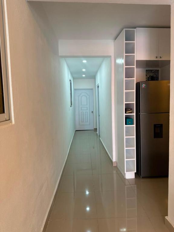 a hallway leading to a kitchen with a refrigerator at Los Alcarrizos Puente Blanco Urban Oasis ubicado en la calle 22 numero 98 los alcarrizos in Santo Domingo