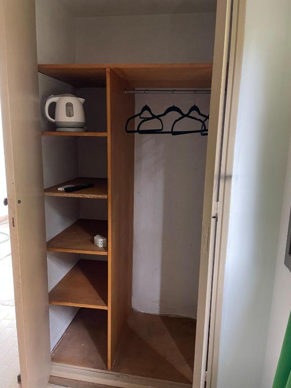 a closet with wooden shelves and a computer on it at Private room with bathroom in Mendoza
