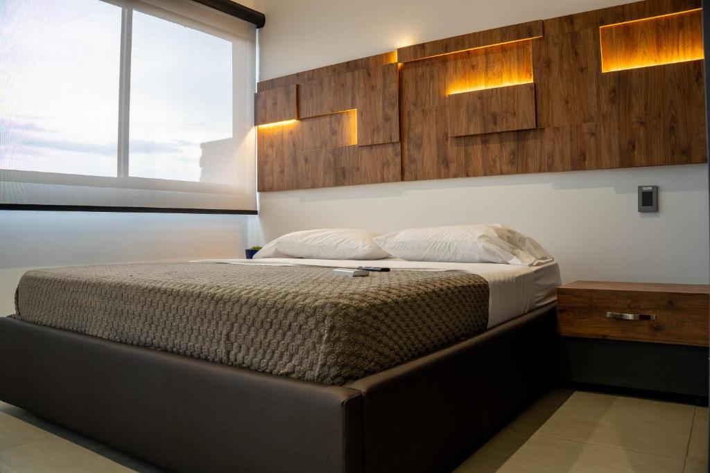 a bedroom with a bed in a room with a window at Patio Alto Rooftop in Buga