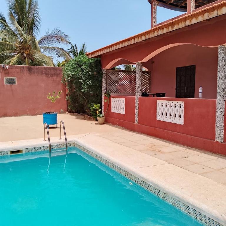 a swimming pool in front of a house at Keur Diédhiou in Saly Portudal