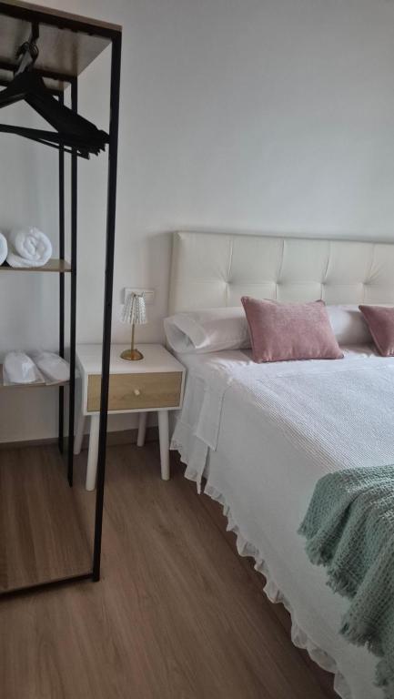 a bedroom with a bed and a table with a lamp at La Divina 1 in Ribadavia
