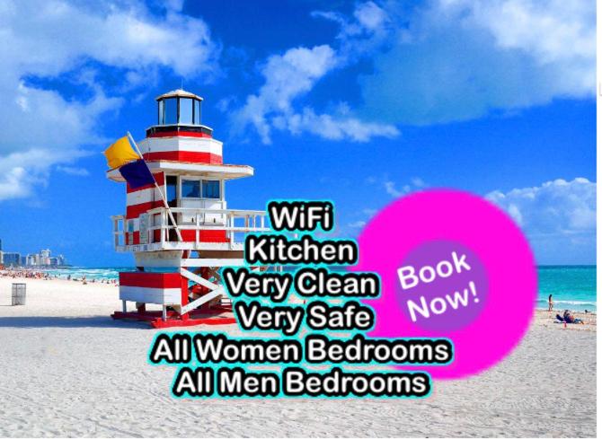 a sign on a beach with a lighthouse on the beach at Hola - Brickell- Bayside Wynwood - Downtown - WiFi - Female Dorms and Male Dorms - No Mixed in Miami