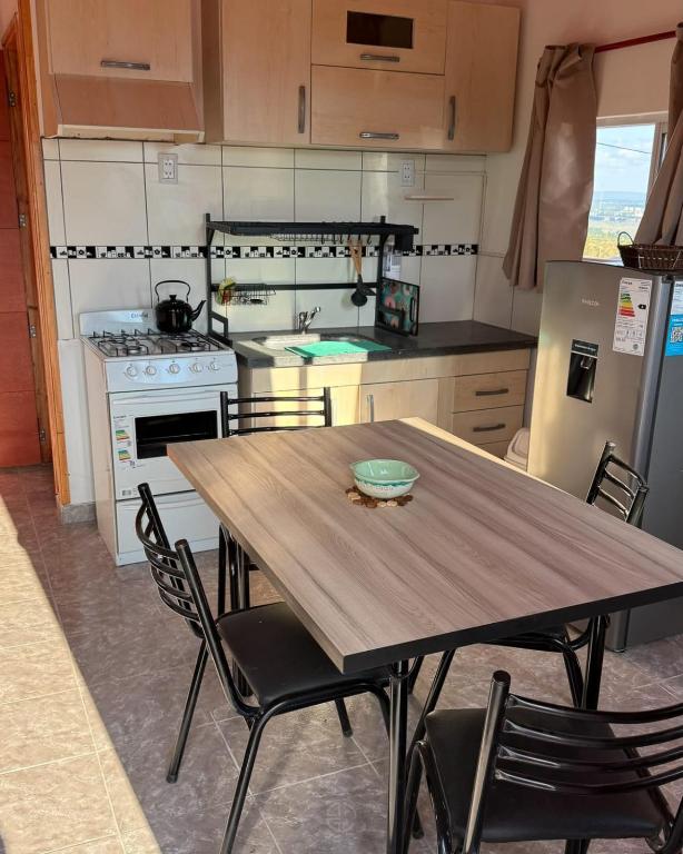 a kitchen with a wooden table and chairs at Cuchac Cuchic in Las Compuertas